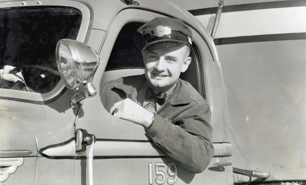 WHI Image ID #62071 Davis Campbell, Decatur Cartage Company's safe driver, leans out the driver's window of an International truck, smiling.